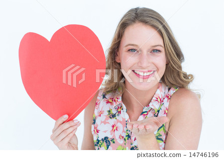 Woman holding heart card and blowing kiss Woman holding heart card and blowing kiss 14746196