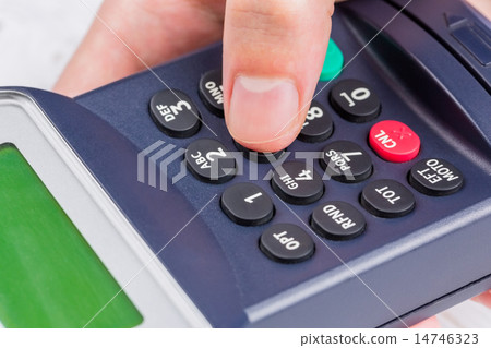 Man entering his pin on terminal 14746323