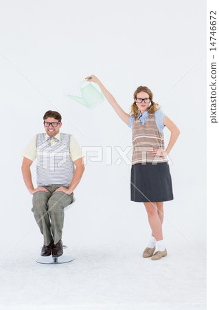 Geeky hipster holding watering can above her boyfriend 14746672
