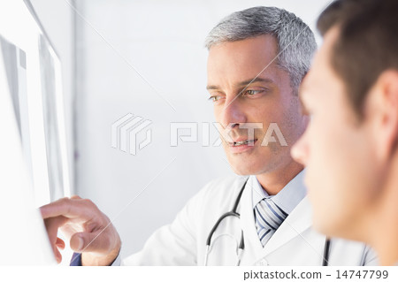 Doctor showing X rays to his patient Doctor showing X rays to his patient 14747799