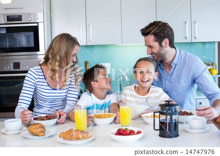 Happy family having breakfast together Happy family having breakfast together 14747976