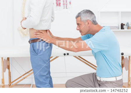 Doctor examining his patient back Doctor examining his patient back 14748252