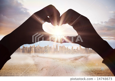 Composite image of woman making heart shape with hands Composite image of woman making heart shape with hands 14748673