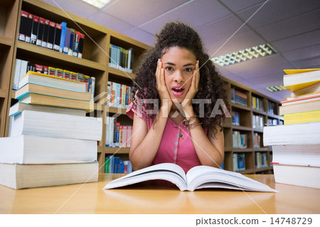 Pretty student studying in the library Pretty student studying in the library 14748729