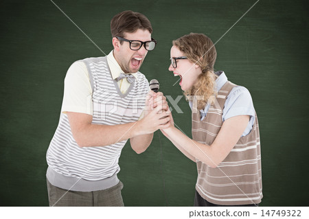 Composite image of geeky hipster couple singing into a microphon 14749322