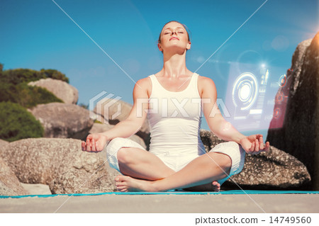 Composite image of blonde woman sitting in lotus pose on beach o Composite image of blonde woman sitting in lotus pose on beach o 14749560