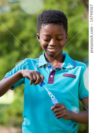 Little boy blowing bubbles in the park Little boy blowing bubbles in the park 14749567