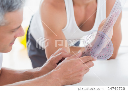 Doctor measuring wrist with goniometer 14749720