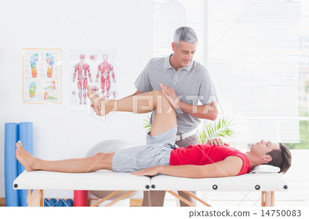 Physiotherapist doing leg massage to his patient 14750083
