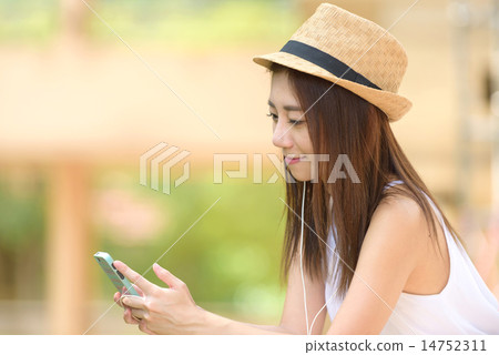 Young Chinese woman listening to music Young Chinese woman listening to music 14752311