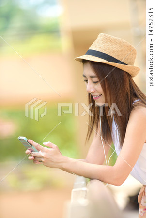 Young Chinese woman listening to music Young Chinese woman listening to music 14752315