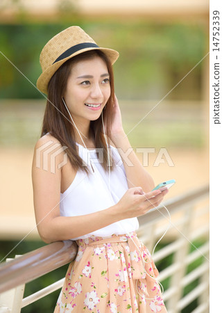 Young Chinese woman listening to music Young Chinese woman listening to music 14752339