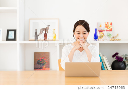 A woman using a computer in the living room 14758963