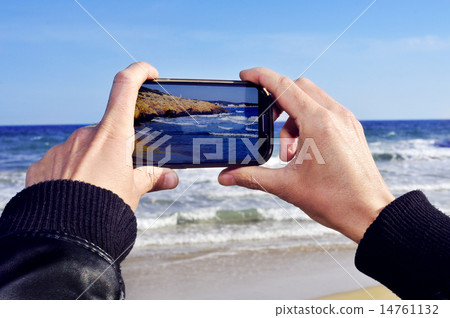 someone taking a picture of a beach with a smartphone someone taking a picture of a beach with a smartphone 14761132