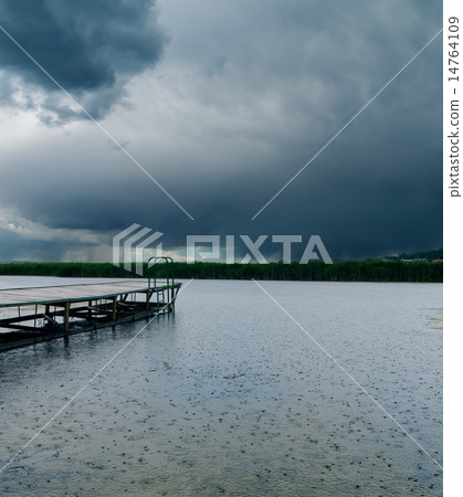 drops of rain on river under dark clouds drops of rain on river under dark clouds 14764109