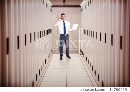 Composite image of businessman on the phone holding laptop 14766439