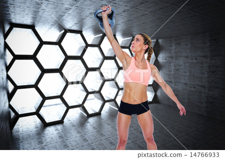 Composite image of female crossfitter lifting up kettlebell 14766933