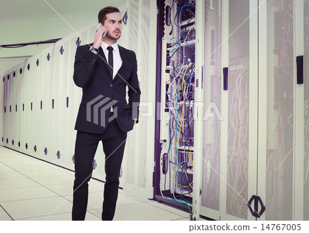 Composite image of serious businessman hand in pocket phoning 14767005