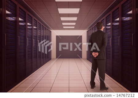 Composite image of businessman standing and looking 14767212