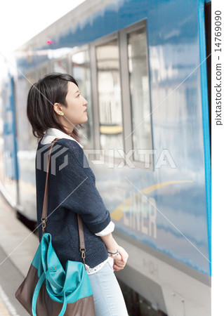 A young lady waiting for a train at the station home 14769090