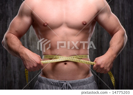 Close up of well formed man measuring his waist 14775203