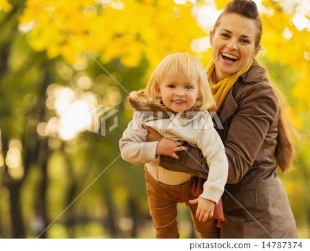 Young mother playing with baby outdoors Young mother playing with baby outdoors 14787374