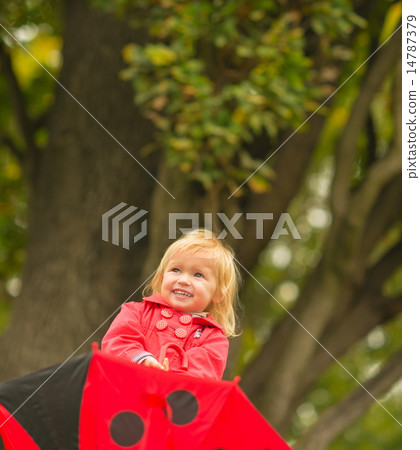 Portrait of laughing baby with red umbrella looking up Portrait of laughing baby with red umbrella looking up 14787379