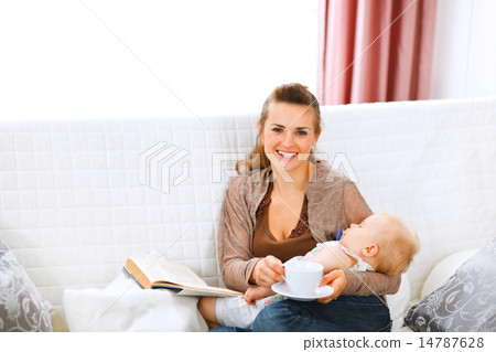 Young mom resting while baby sleep by having coffee and reading 14787628