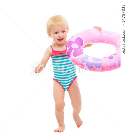 Baby in swimsuit playing with inflatable ring 14787835