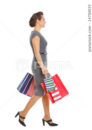Woman in dress walking with shopping bags 14788035
