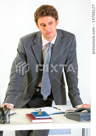 Portrait of thoughtful modern businessman holding hands on offic 14788227