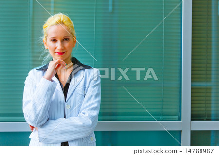 Pensive business woman with hand near face standing near office 14788987