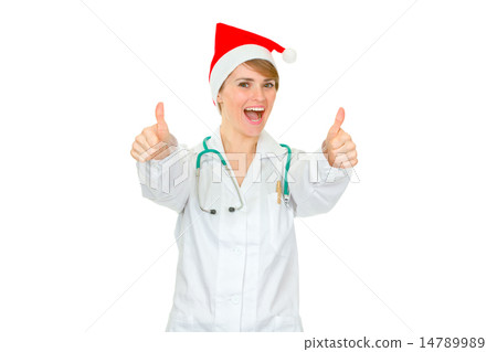 Happy medical doctor woman in Santa hat showing thumbs up gesture. 14789989