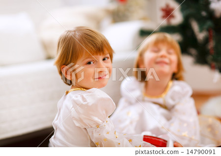 Portrait of happy girl playing with sister near Christmas tree 14790091