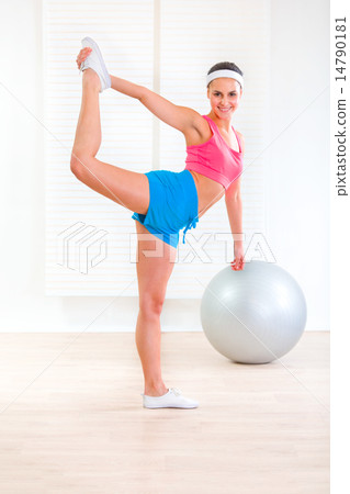 Cheerful fitness young girl doing stretching exercises at home. Cheerful fitness young girl doing stretching exercises at home. 14790181