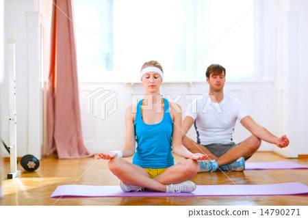 Young man and fit woman doing yoga at home 14790271