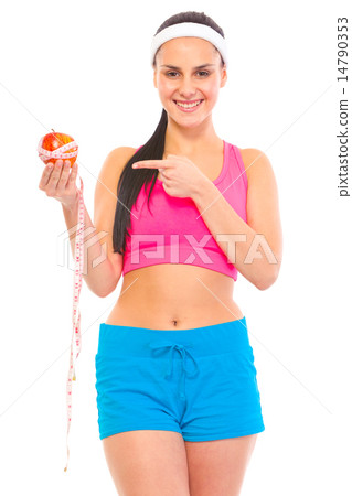 Smiling young fit girl pointing finger on apple with measuring tape. 14790353