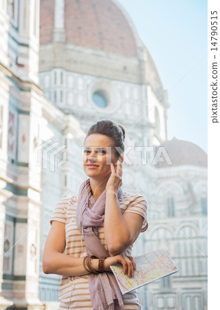 Happy young woman with map and audio guide in front of cattedral 14790515