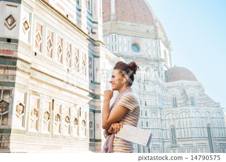 Happy young woman with map and audio guide in front of cattedral Happy young woman with map and audio guide in front of cattedral 14790575