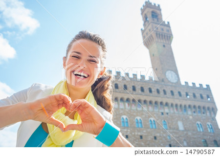 Happy young woman showing heart gesture shaped hands in front of Happy young woman showing heart gesture shaped hands in front of 14790587