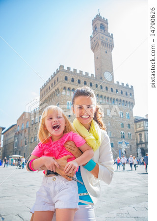 Portrait of smiling mother and baby girl in front of palazzo vec 14790626