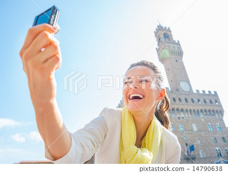Happy young woman making selfie in front of palazzo vecchio in f Happy young woman making selfie in front of palazzo vecchio in f 14790638