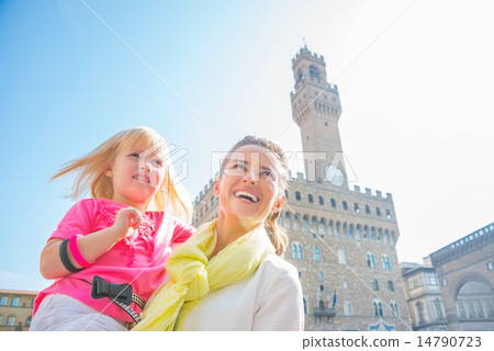 Happy mother and baby girl looking into distance in front of pal 14790723