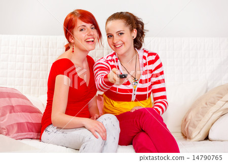 Smiling lovely girls watching TV Smiling lovely girls watching TV 14790765