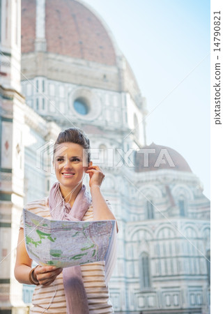 Portrait of happy young woman with map and audio guide in front 14790821