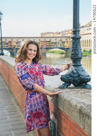Happy young woman on embankment near ponte vecchio in florence, 14790822