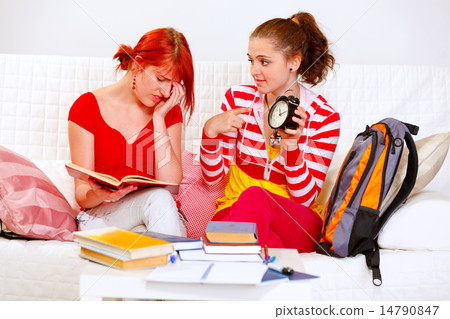 Girl showing her studying girlfriends clock 14790847