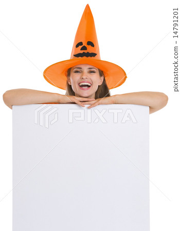Smiling woman in Halloween hat with blank billboard 14791201
