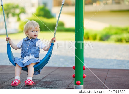 Baby swinging on swing on playground. Side view 14791821