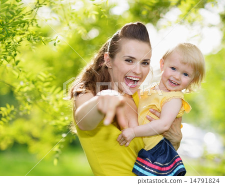 Portrait of baby girl and smiling mother pointing in camera Portrait of baby girl and smiling mother pointing in camera 14791824